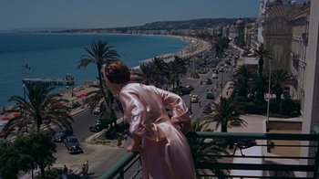 Movie still from “To Catch a Thief” (1955), directed by Alfred Hitchcock – A woman standing on a balcony looking at the ocean; Extreme Wide shot, High angle