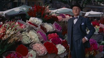 Movie still from “To Catch a Thief” (1955), directed by Alfred Hitchcock – A man standing in front of a bunch of flowers; Medium shot, High angle