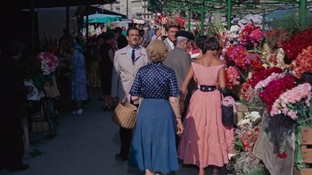 Movie still from “To Catch a Thief” (1955), directed by Alfred Hitchcock – A group of people standing around a flower market; Wide shot, High angle