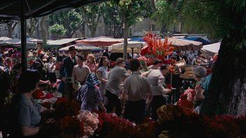 Movie still from “To Catch a Thief” (1955), directed by Alfred Hitchcock – A group of people walking around a flower market; Extreme Wide shot, High angle