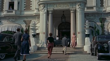 Movie still from “To Catch a Thief” (1955), directed by Alfred Hitchcock – A group of people walking down a sidewalk; Wide shot, Low angle