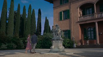 Movie still from “To Catch a Thief” (1955), directed by Alfred Hitchcock – A man and a woman are standing in front of a statue; Extreme Wide shot, Low angle