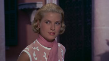 Movie still from “To Catch a Thief” (1955), directed by Alfred Hitchcock – A woman with blonde hair wearing a pink top; Close Up shot, Low angle