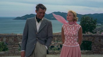 Movie still from “To Catch a Thief” (1955), directed by Alfred Hitchcock – A man and a woman standing next to each other on a hill; Medium shot, Over the shoulder angle