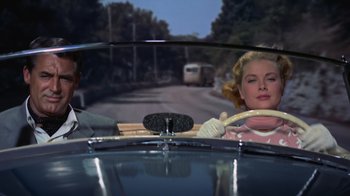 A man and a woman driving a car down a street