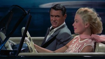 Movie still from “To Catch a Thief” (1955), directed by Alfred Hitchcock – A man and a woman sitting in a car; Medium shot, Over the shoulder angle