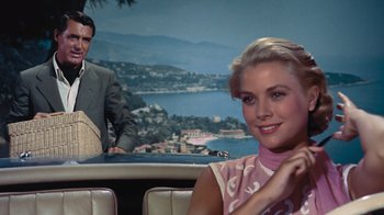 Movie still from “To Catch a Thief” (1955), directed by Alfred Hitchcock – A man and a woman sitting in a booth; Medium shot, Over the shoulder angle