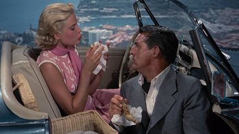 Movie still from “To Catch a Thief” (1955), directed by Alfred Hitchcock – A man and a woman are eating a sandwich; Medium shot, High angle