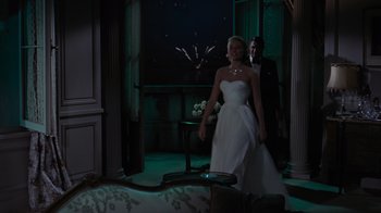 Movie still from “To Catch a Thief” (1955), directed by Alfred Hitchcock – A woman in a white dress standing next to a man in a suit; Wide shot, Over the shoulder angle