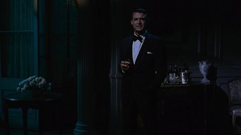 Movie still from “To Catch a Thief” (1955), directed by Alfred Hitchcock – A man in a tuxedo holding a glass of wine; Medium shot, Over the shoulder angle