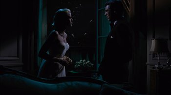 Movie still from “To Catch a Thief” (1955), directed by Alfred Hitchcock – A man and a woman standing next to each other in front of a window; Medium shot, Low angle