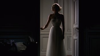 Movie still from “To Catch a Thief” (1955), directed by Alfred Hitchcock – A woman in a white dress standing in front of a door; Wide shot, Low angle