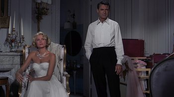 Movie still from “To Catch a Thief” (1955), directed by Alfred Hitchcock – A man and a woman standing next to each other in a room; Medium shot, Low angle