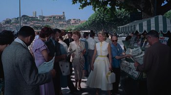Movie still from “To Catch a Thief” (1955), directed by Alfred Hitchcock – A group of people standing on the sidewalk; Wide shot, Low angle