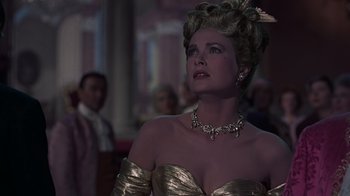 Movie still from “To Catch a Thief” (1955), directed by Alfred Hitchcock – A woman in a gold dress and a gold necklace; Close Up shot, Over the shoulder angle