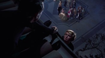 Movie still from “To Catch a Thief” (1955), directed by Alfred Hitchcock – A woman in a black dress is looking in a mirror; Wide shot, High angle