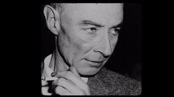 Movie still from “To End All War: Oppenheimer & the Atomic Bomb” (2023), directed by Christopher Cassel – An old black and white photo of a man; Close Up shot, Overhead angle