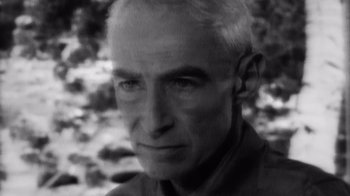 Movie still from “To End All War: Oppenheimer & the Atomic Bomb” (2023), directed by Christopher Cassel – An older man with white hair is looking at the camera; Close Up shot, High angle