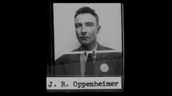 Movie still from “To End All War: Oppenheimer & the Atomic Bomb” (2023), directed by Christopher Cassel – An old black and white photo of a man in a suit and tie; Close Up shot, Overhead angle