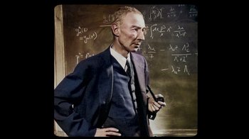 Movie still from “To End All War: Oppenheimer & the Atomic Bomb” (2023), directed by Christopher Cassel – An older man standing in front of a chalkboard; Close Up shot, High angle