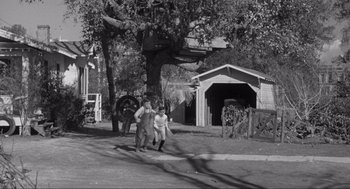 Movie still from “To Kill a Mockingbird” (1962), directed by Robert Mulligan – A man and a woman walking down a street; Wide shot, High angle
