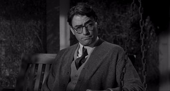 Movie still from “To Kill a Mockingbird” (1962), directed by Robert Mulligan – An old photo of a man sitting on a bench; Medium shot, Over the shoulder angle