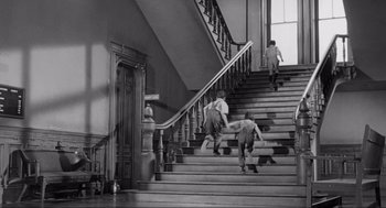 Movie still from “To Kill a Mockingbird” (1962), directed by Robert Mulligan – Two boys are running up the stairs of a house; Wide shot, Low angle