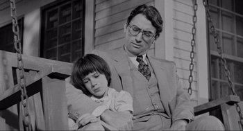 Movie still from “To Kill a Mockingbird” (1962), directed by Robert Mulligan – A man and a boy sitting on a bench; Medium shot, Low angle