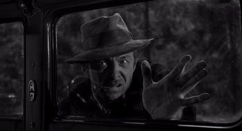 Movie still from “To Kill a Mockingbird” (1962), directed by Robert Mulligan – A black and white photo of a man in a hat looking out of a car window; Close Up shot, Over the shoulder angle