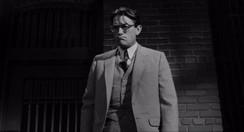 Movie still from “To Kill a Mockingbird” (1962), directed by Robert Mulligan – A black and white photo of a man wearing a suit and tie; Medium shot, Low angle