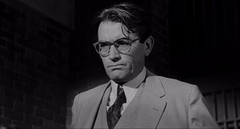 Movie still from “To Kill a Mockingbird” (1962), directed by Robert Mulligan – A man in a suit and tie wearing glasses; Close Up shot, Over the shoulder angle