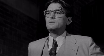 Movie still from “To Kill a Mockingbird” (1962), directed by Robert Mulligan – A man in a suit and tie wearing glasses; Close Up shot, Low angle