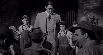 Movie still from “To Kill a Mockingbird” (1962), directed by Robert Mulligan – An old photo of a man in a suit with children; Medium shot, Low angle