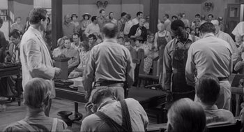 Movie still from “To Kill a Mockingbird” (1962), directed by Robert Mulligan – A group of people sitting in a room; Wide shot, High angle