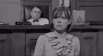 Movie still from “To Kill a Mockingbird” (1962), directed by Robert Mulligan – A woman sitting in front of a man in a courtroom; Medium shot, Over the shoulder angle