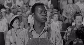 Movie still from “To Kill a Mockingbird” (1962), directed by Robert Mulligan – A black and white photo of a man in overalls; Medium shot, Over the shoulder angle