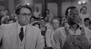 Movie still from “To Kill a Mockingbird” (1962), directed by Robert Mulligan – Two men are sitting in front of an audience; Medium shot, Over the shoulder angle
