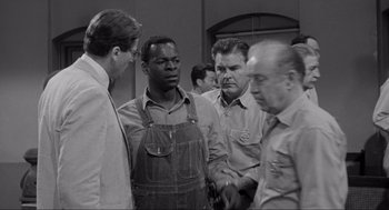 Movie still from “To Kill a Mockingbird” (1962), directed by Robert Mulligan – A black and white photo of a group of men; Medium shot, Over the shoulder angle