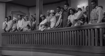 Movie still from “To Kill a Mockingbird” (1962), directed by Robert Mulligan – A group of people standing on a balcony watching something; Wide shot, Low angle