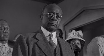 Movie still from “To Kill a Mockingbird” (1962), directed by Robert Mulligan – An older man wearing a suit and tie; Close Up shot, Low angle