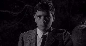 Movie still from “To Kill a Mockingbird” (1962), directed by Robert Mulligan – A young boy wearing a suit and tie in the dark; Close Up shot, High angle