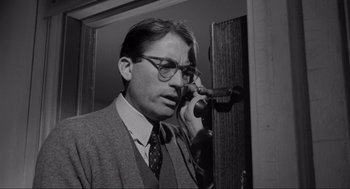 Movie still from “To Kill a Mockingbird” (1962), directed by Robert Mulligan – A man wearing glasses talking on a phone; Close Up shot, Low angle