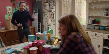 Movie still from “Together” (2021), directed by Justin Martin – A woman sitting in front of a table full of food; Medium shot, Over the shoulder angle