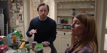 Movie still from “Together” (2021), directed by Justin Martin – A man and a woman sitting at a kitchen table; Medium shot, Over the shoulder angle