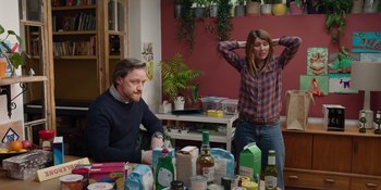 Movie still from “Together” (2021), directed by Justin Martin – A man and a woman sitting at a table with lots of food; Medium shot, Over the shoulder angle