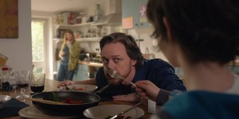 Movie still from “Together” (2021), directed by Justin Martin – A man is eating food while a woman watches; Medium shot, Over the shoulder angle