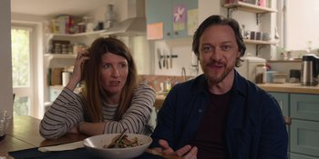 Movie still from “Together” (2021), directed by Justin Martin – A man and a woman sitting in front of a bowl of food; Medium shot, Over the shoulder angle
