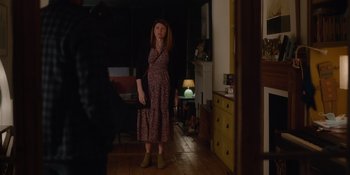 Movie still from “Together” (2021), directed by Justin Martin – A woman standing in a living room in front of a lamp; Wide shot, Over the shoulder angle