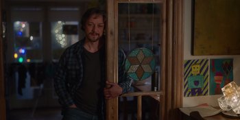 Movie still from “Together” (2021), directed by Justin Martin – A man standing in front of a stained glass window; Medium shot, Over the shoulder angle