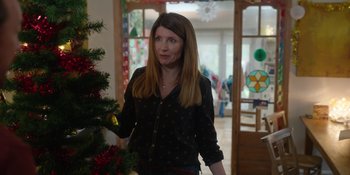 Movie still from “Together” (2021), directed by Justin Martin – A woman standing in front of a christmas tree; Medium shot, Over the shoulder angle